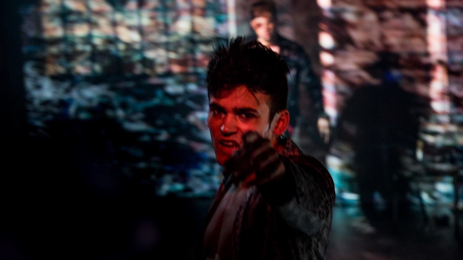 Lead under red light, pointing to the audience