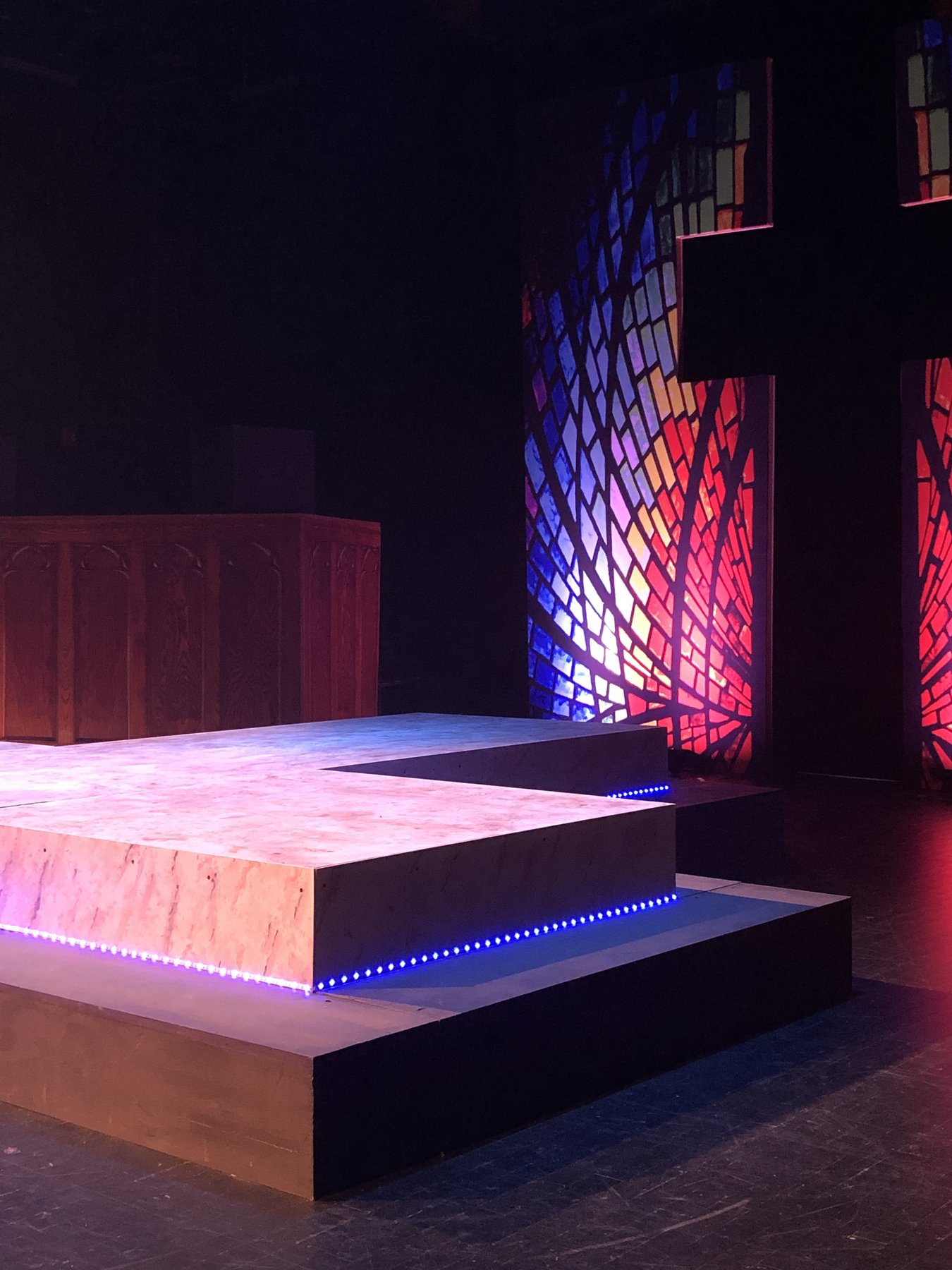 Bare production — LED-edged platform detail with stained glass behind