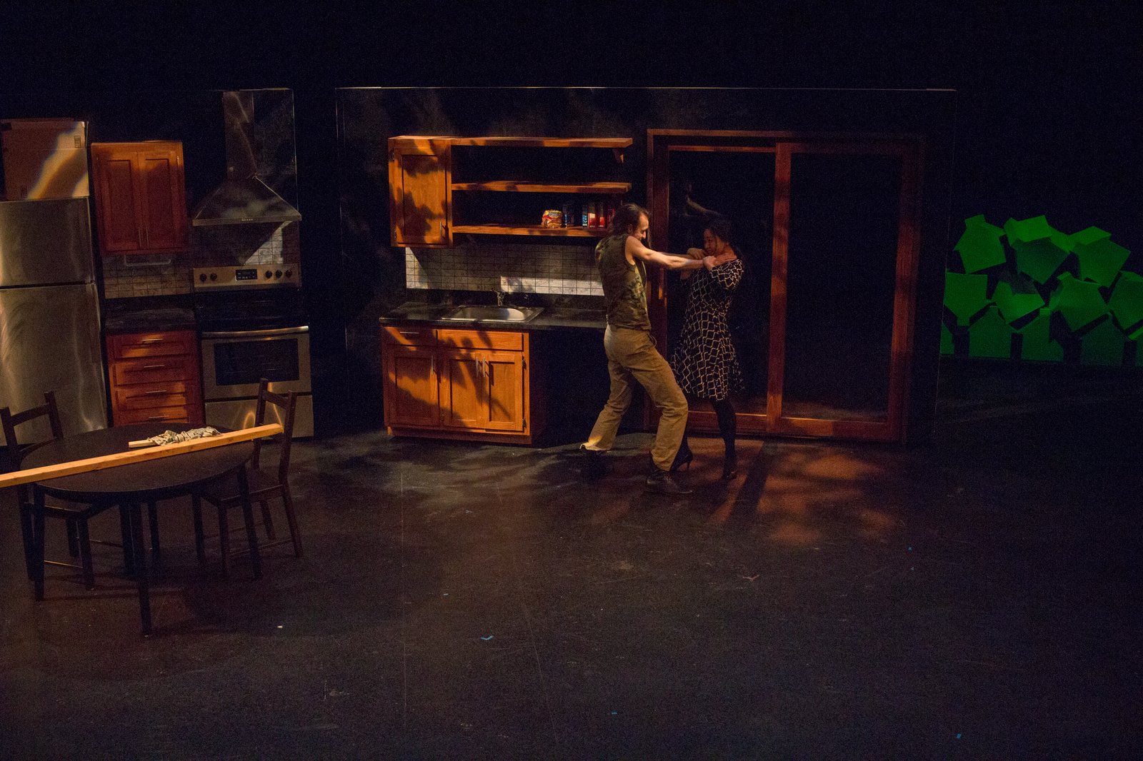 Production photo — the struggle across the table