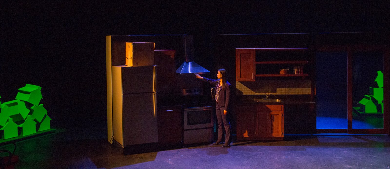 Production photo — the set in dramatic blue and green light