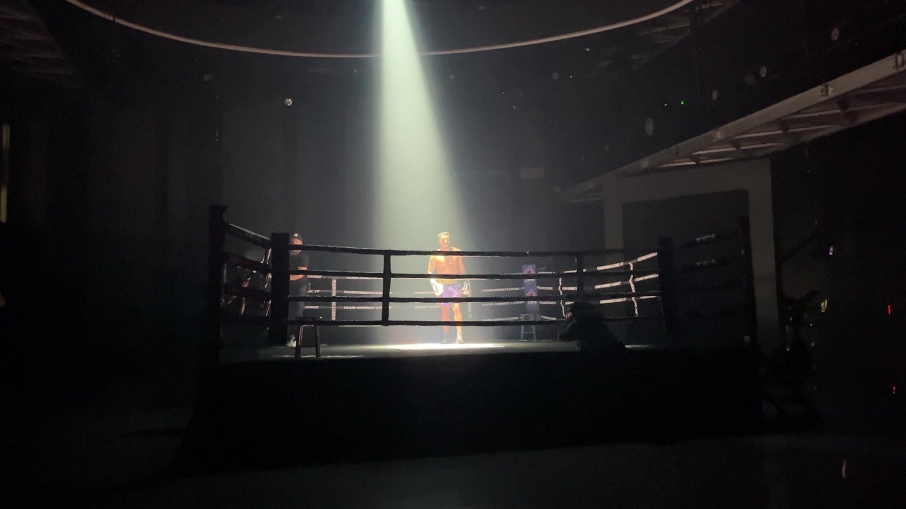 Team Boxing League — a boxer alone in the ring under a single beam