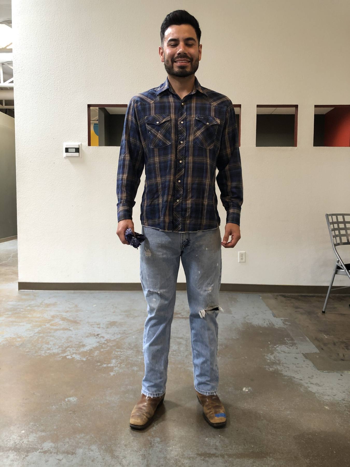 Character fitting — plaid western snap shirt, distressed jeans, cowboy boots