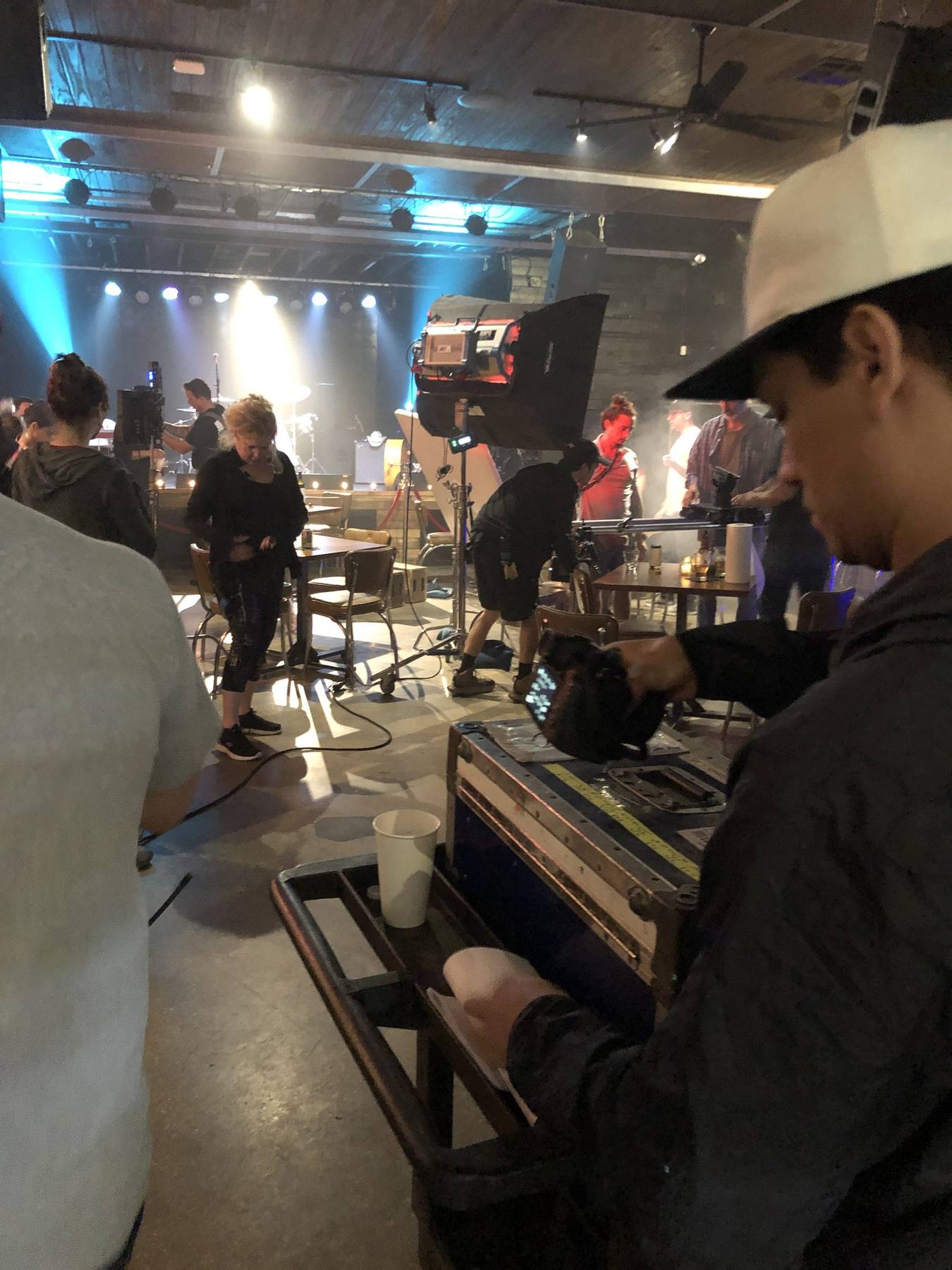 On set — bar scene with styled cast in red atmospheric lighting