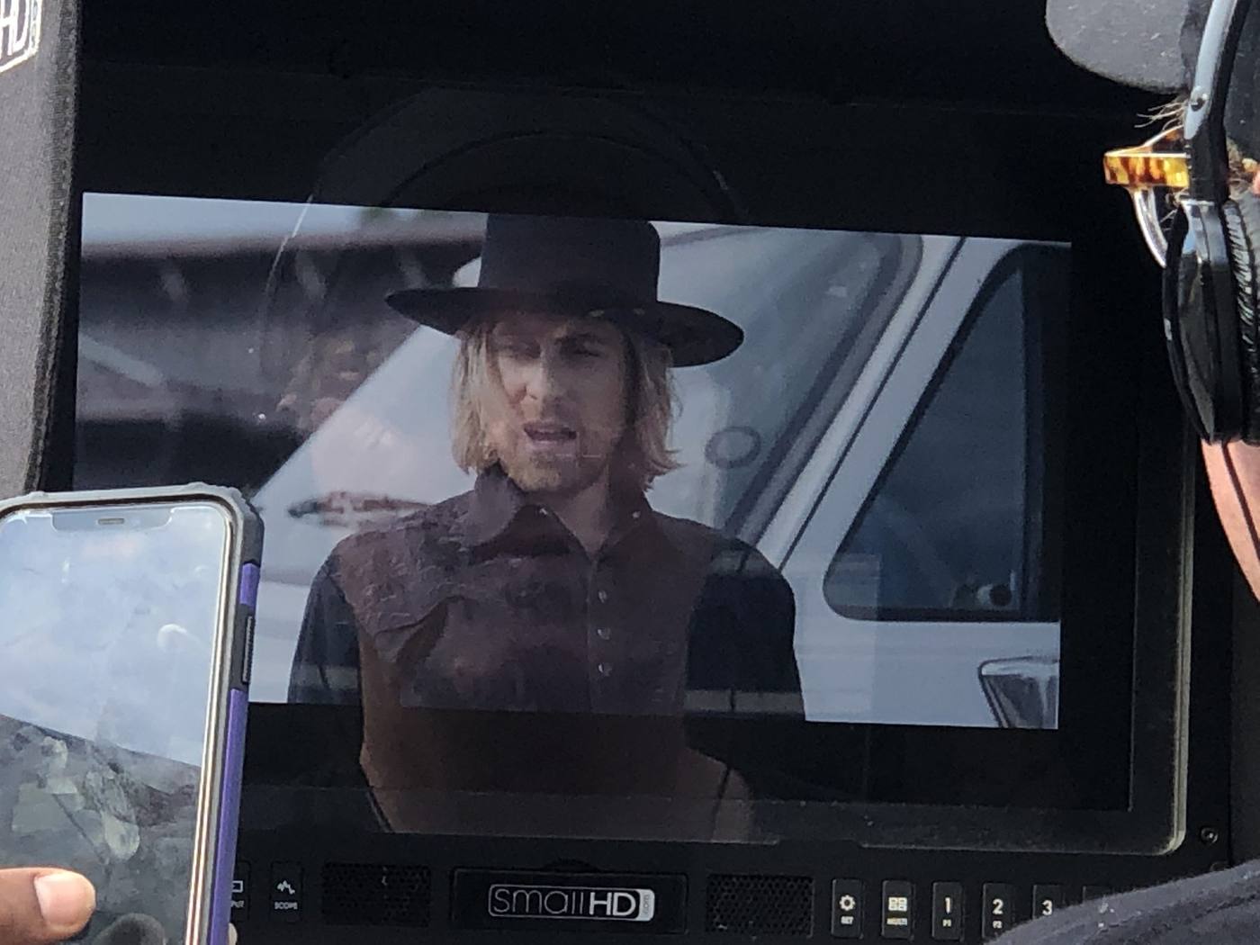 Camera monitor — principal male character, black hat, embossed dark western vest