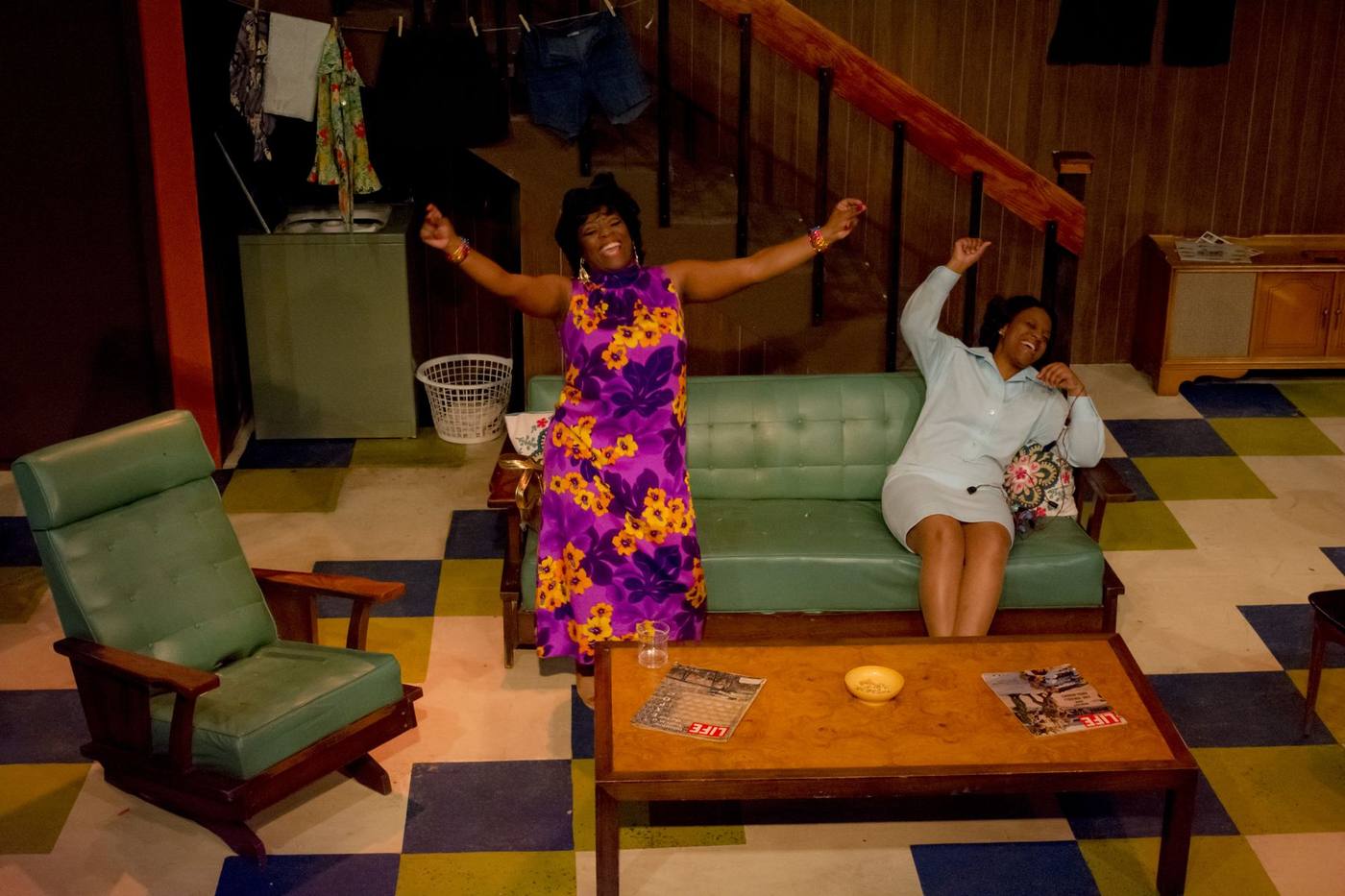 Production photo — two women dancing in the basement