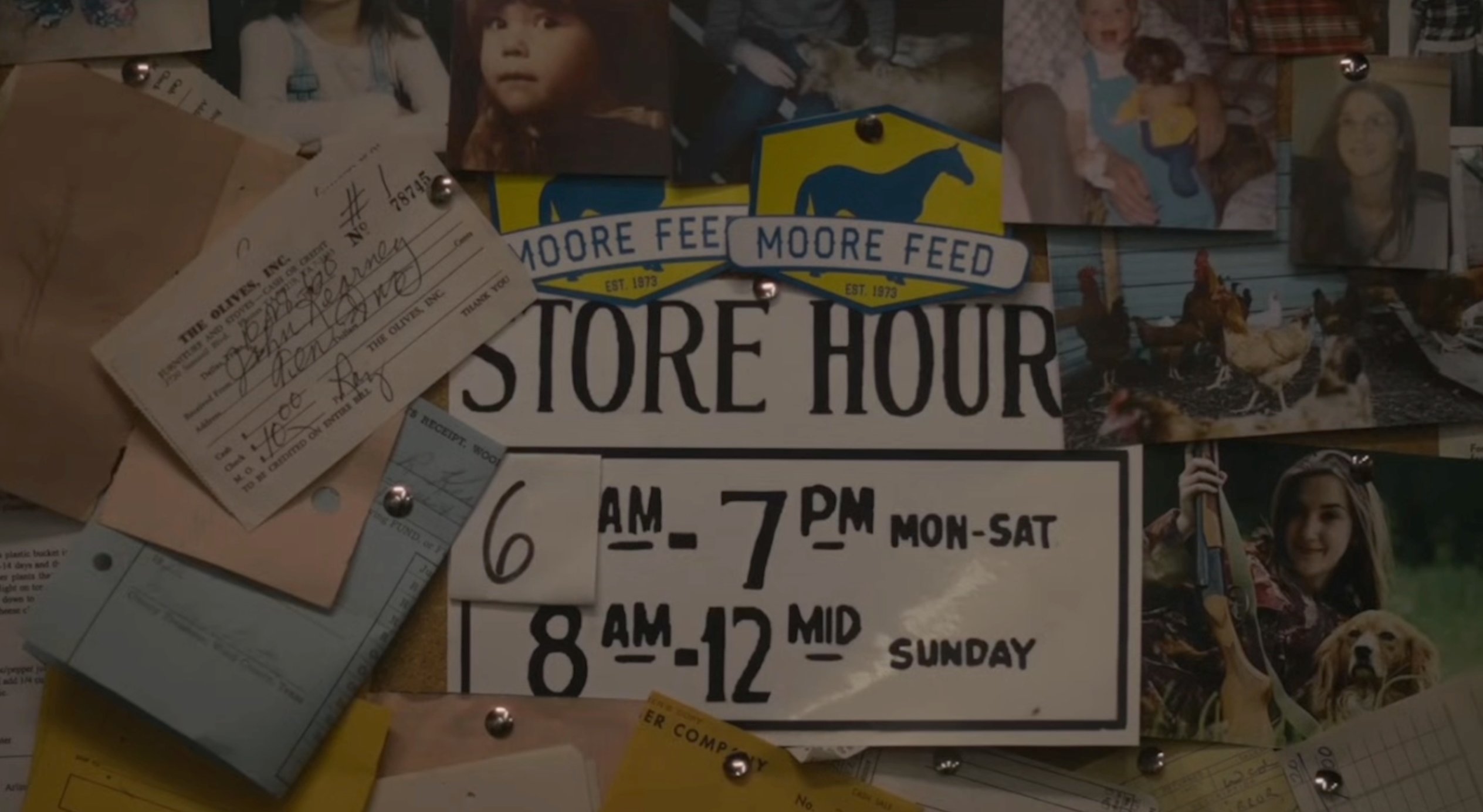 Store corkboard with Moore Feed hours sign and photos