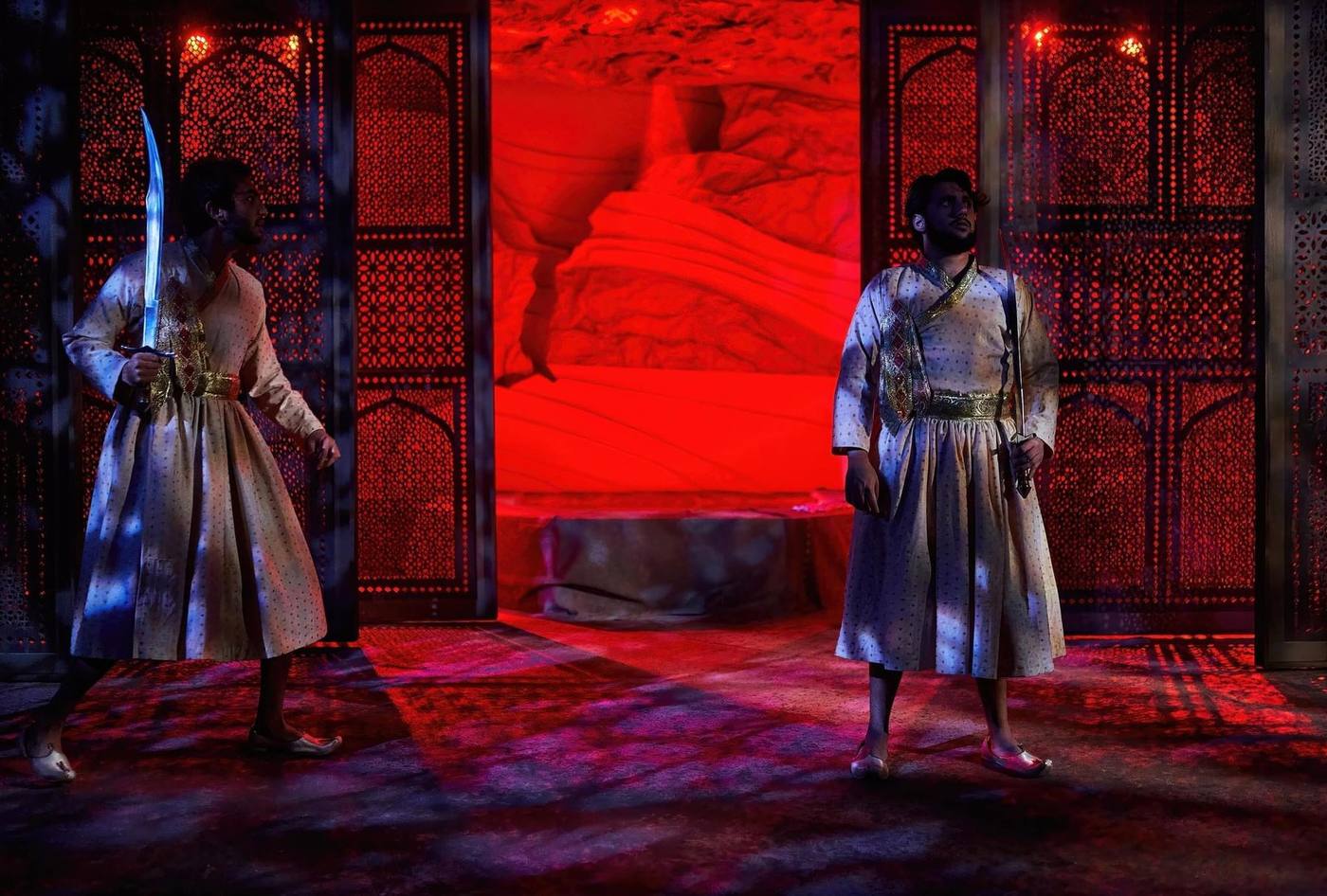 Guards at the Taj — two guards framed by red-lit lattice screens