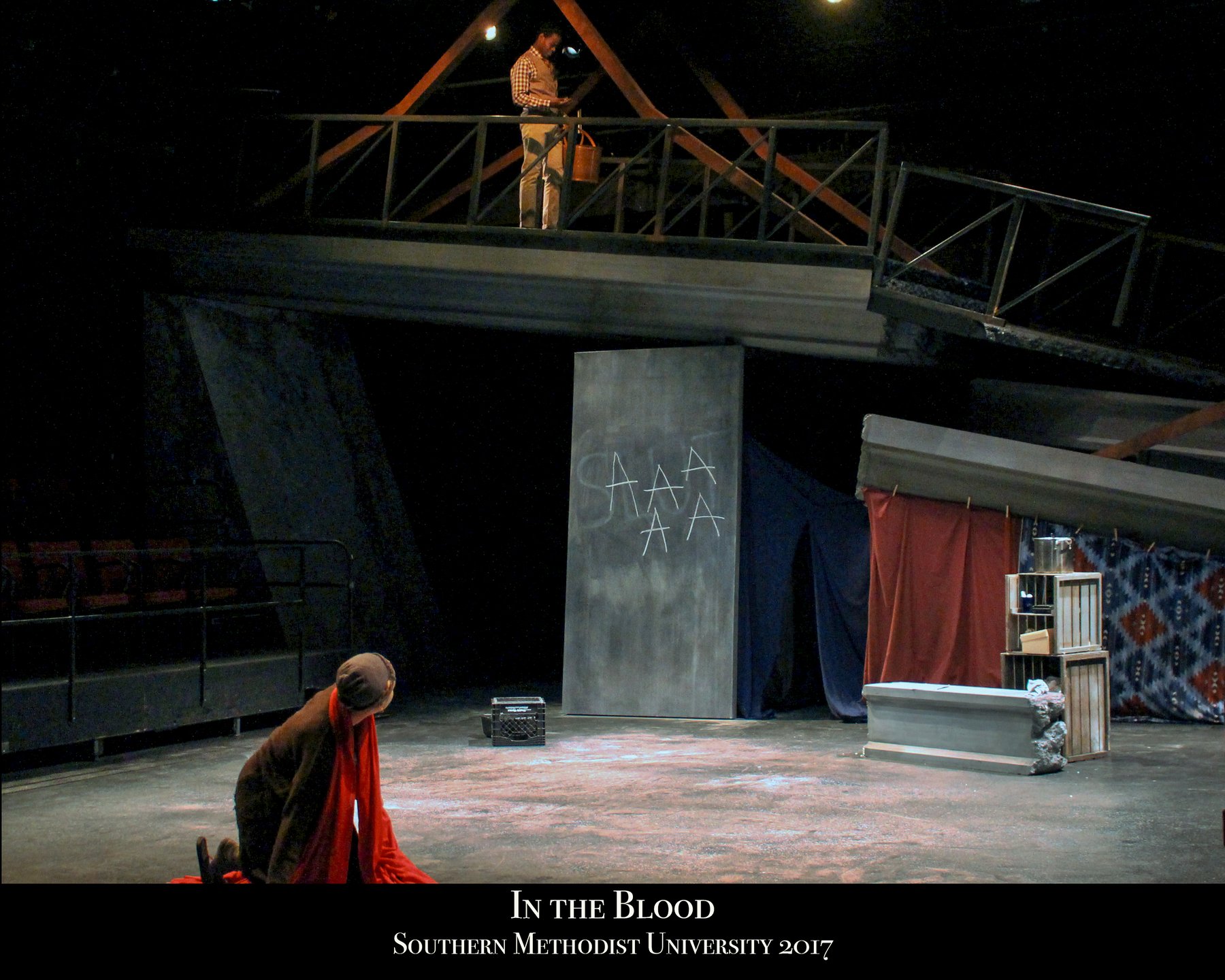 In the Blood — the built set: collapsed overpass, chalk wall, and gobo-broken light