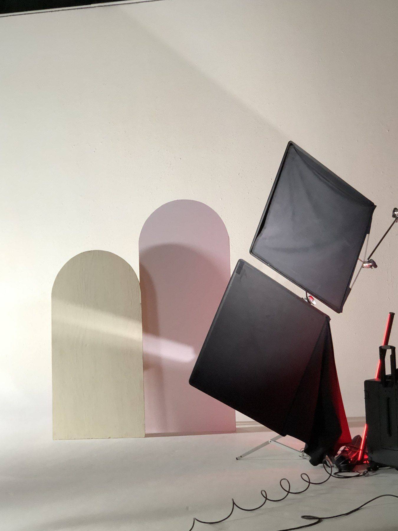 Behind the scenes — styled arch backdrop pieces with softbox lighting