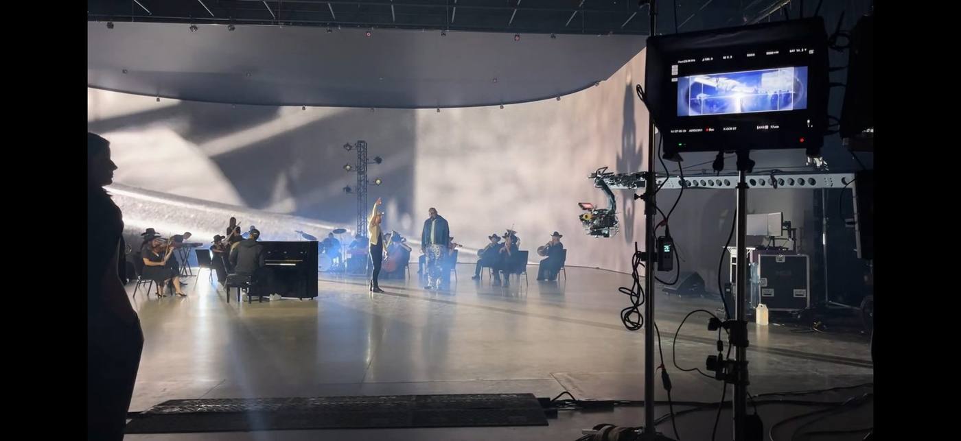 On set wide — hip-hop lead crossing the stage in custom printed pants and denim jacket