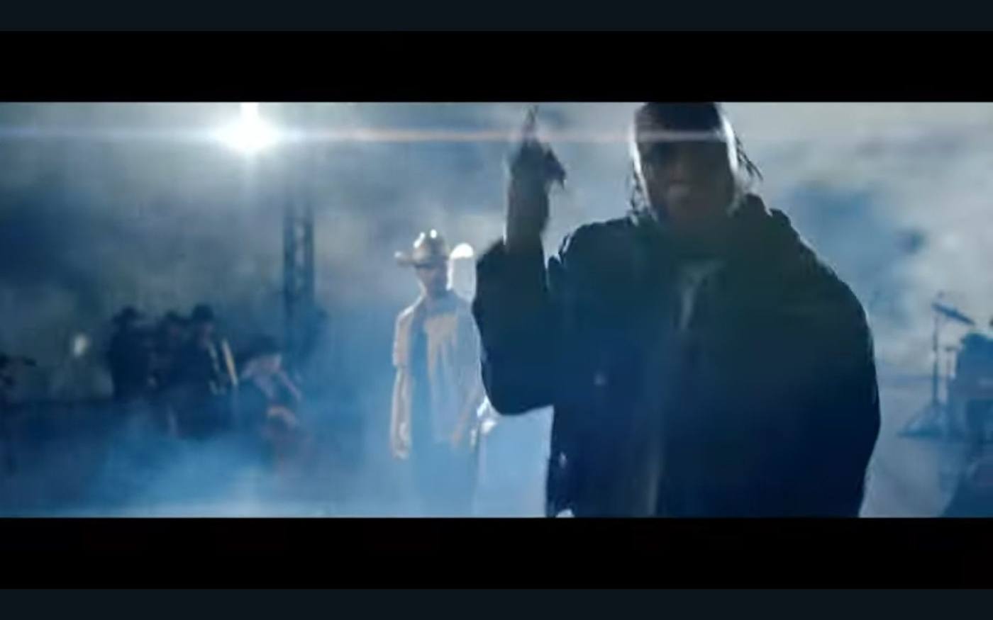 Final still — hip-hop lead in foreground, country lead in cowboy hat in soft focus background