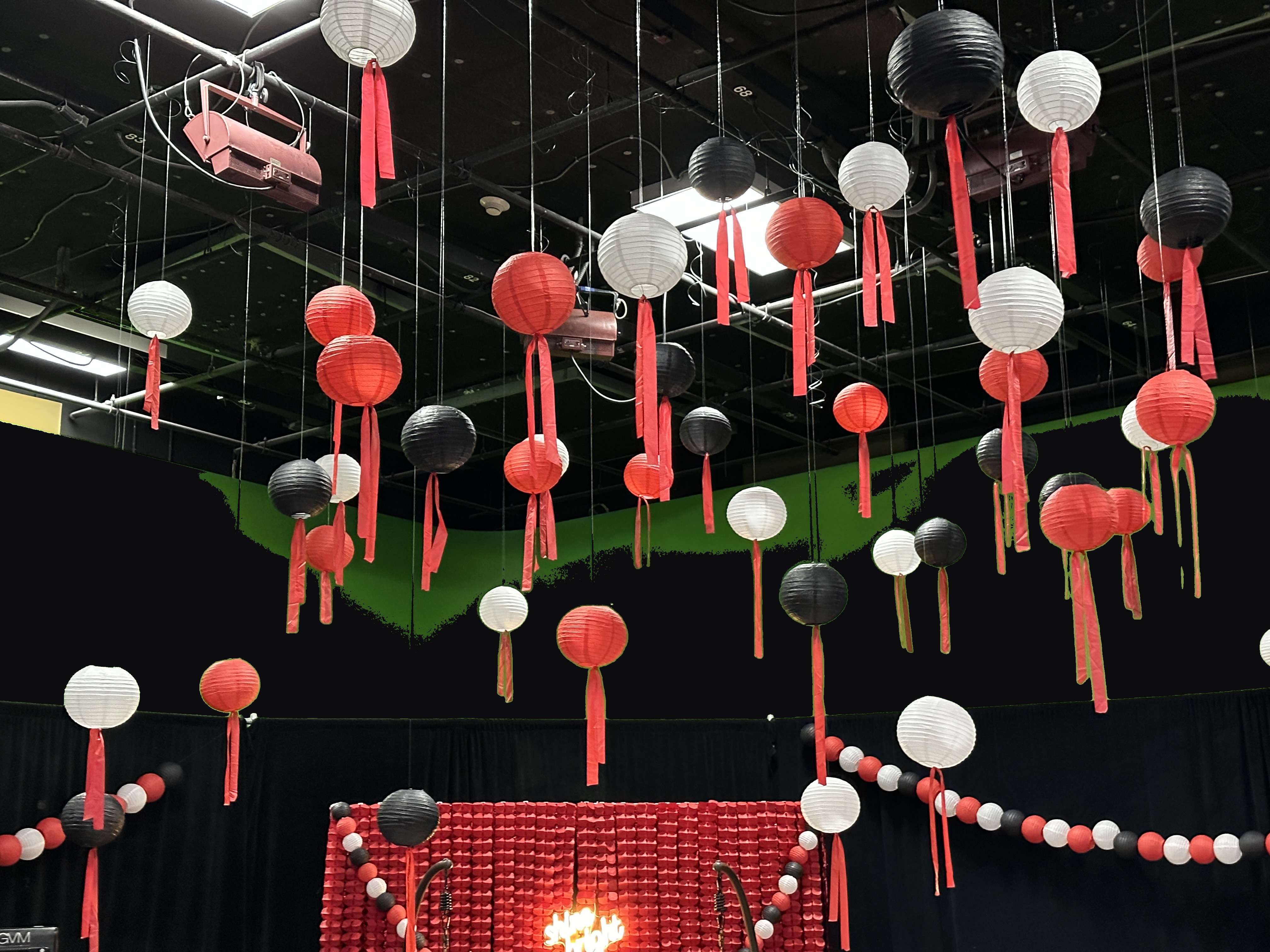 Hanging paper-lantern ceiling in red, black and white over the red photo wall