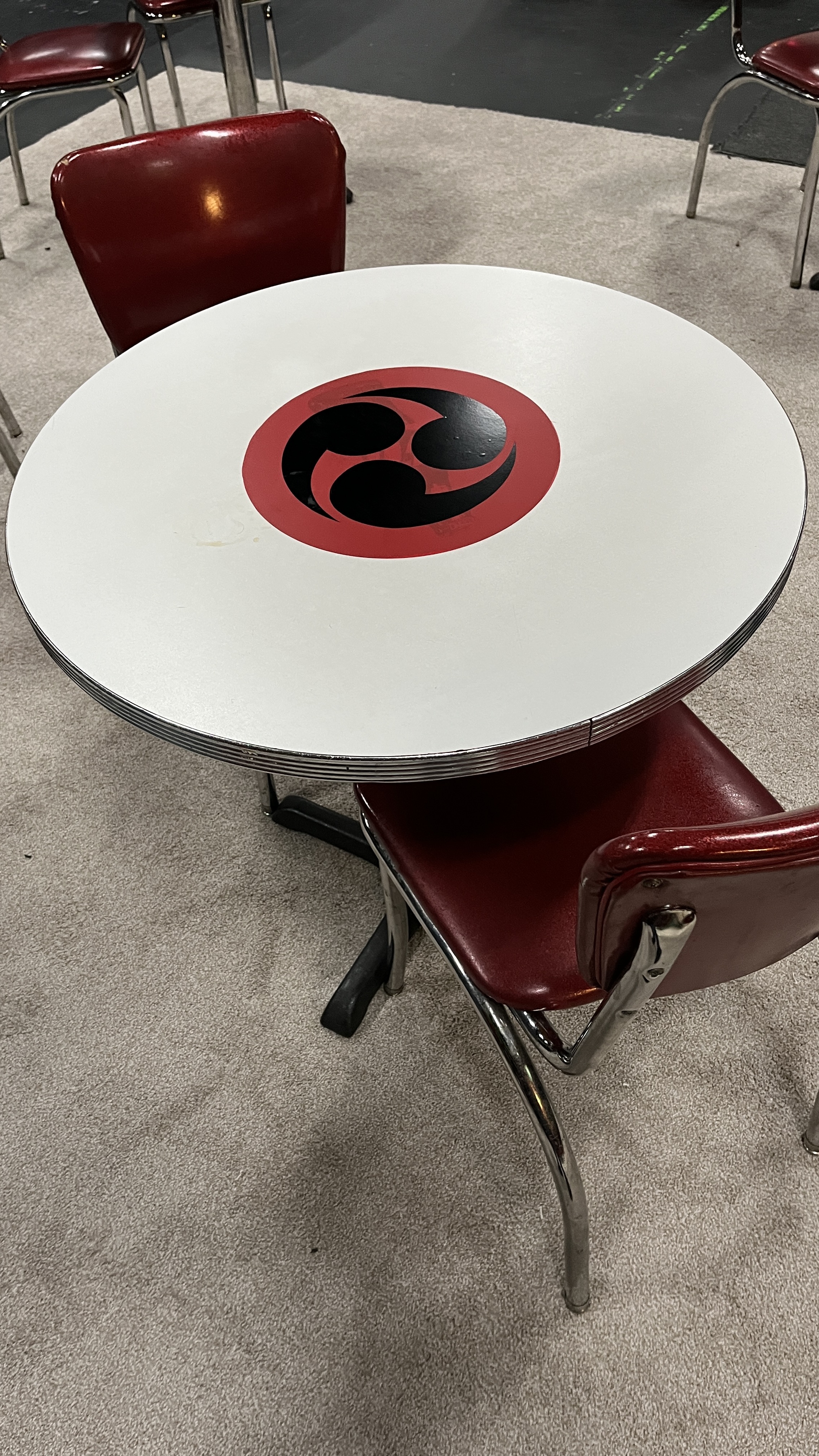 Café table with the custom Taiko tomoe drum-crest graphic