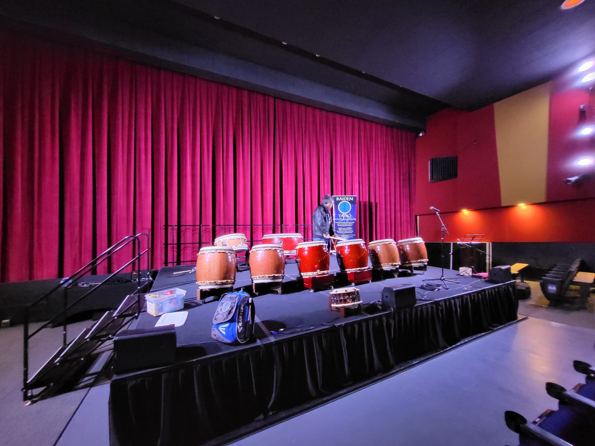 The Taiko drums set on the red-curtain stage before the performance